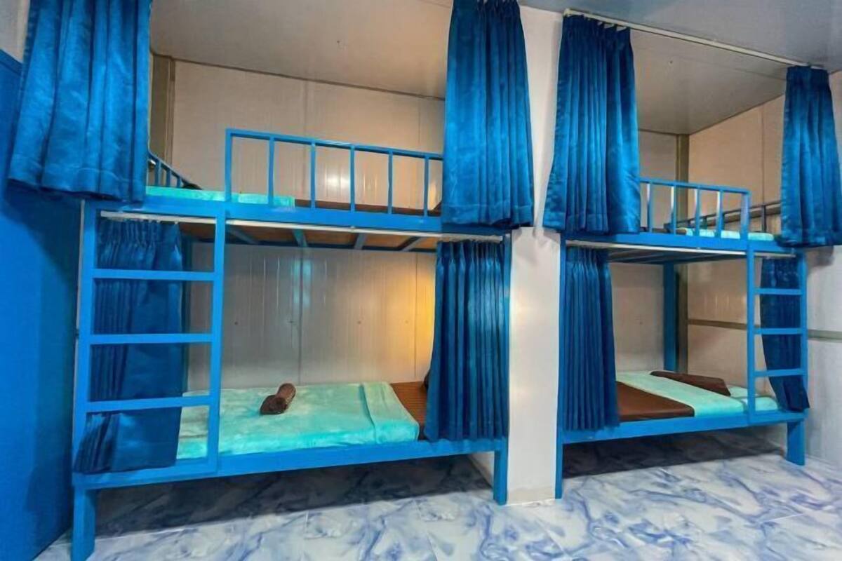 A bunk bed room with blue curtains and a marble floor.