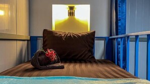 A hotel room with a bed, a pillow, a bag, and a wall-mounted light fixture. - Blue Shore Pavilion (Sihanoukville)