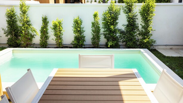 A rectangular pool with a wooden deck and white lounge chairs. - Luxury Villa Artemis (Palermo)