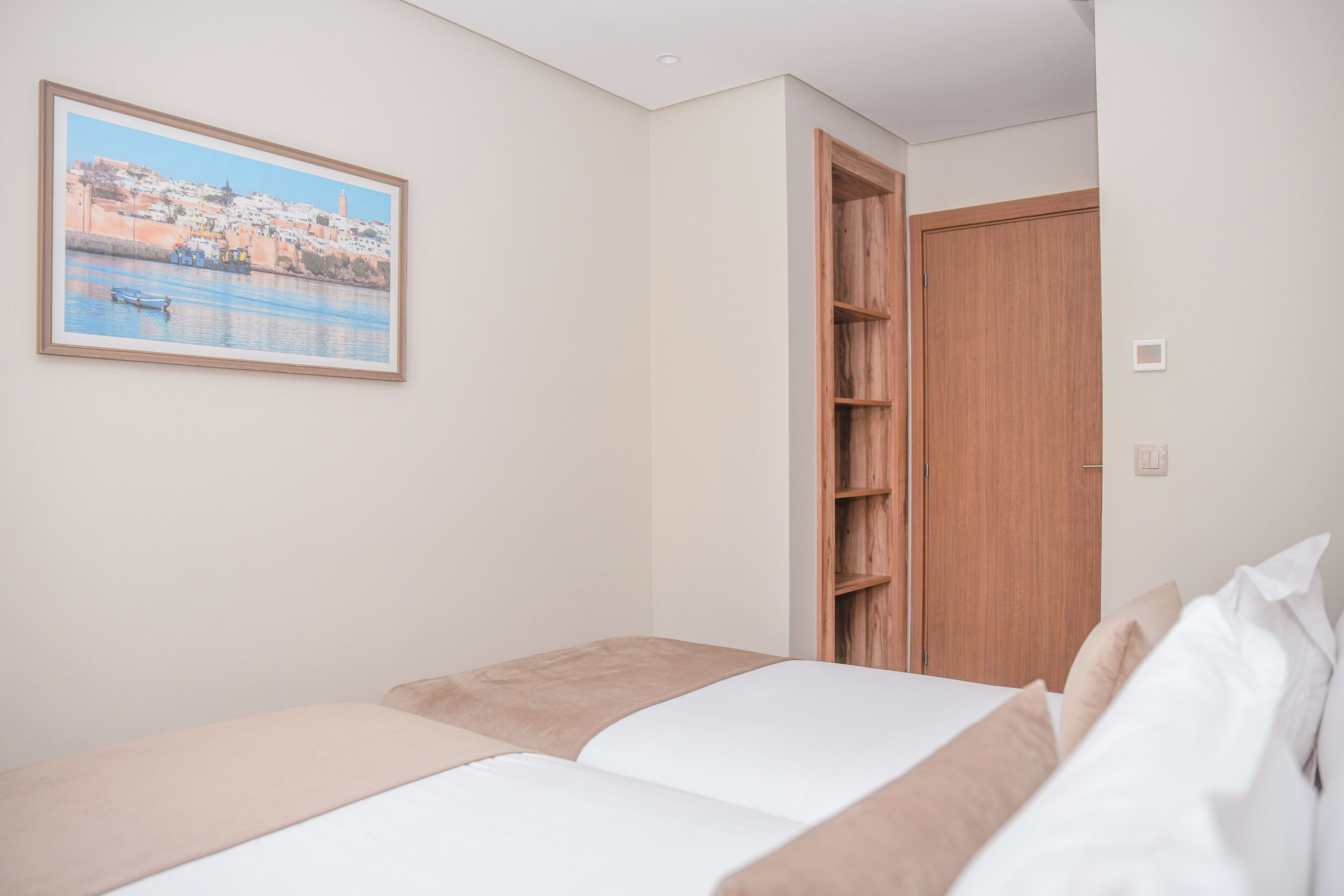 Ein Schlafzimmer mit einem Bett, einem Holzschrank und einem gerahmten Bild an der Wand.