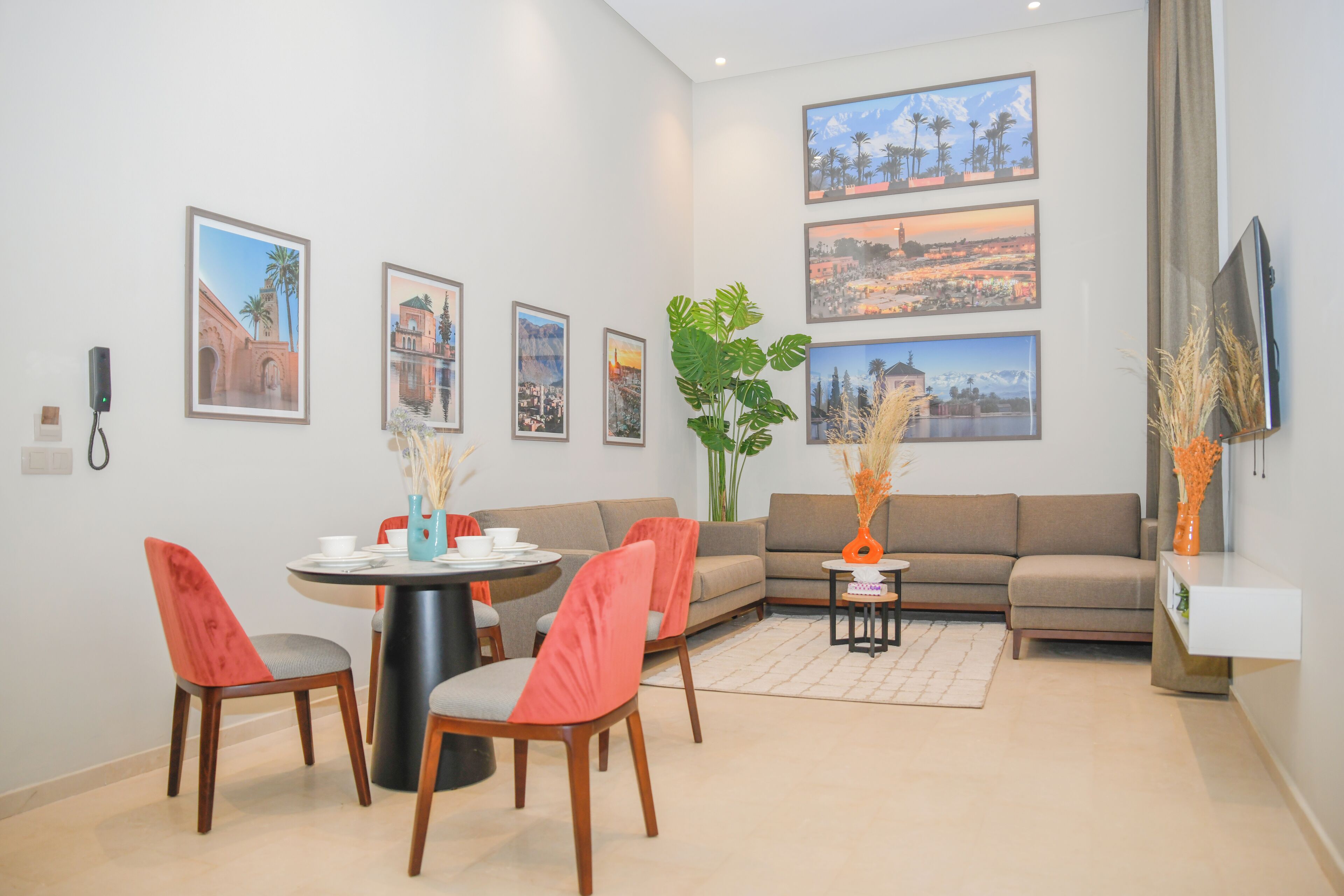 Een moderne woonkamer met een eethoek, met een bank, stoelen, een salontafel en een televisie.