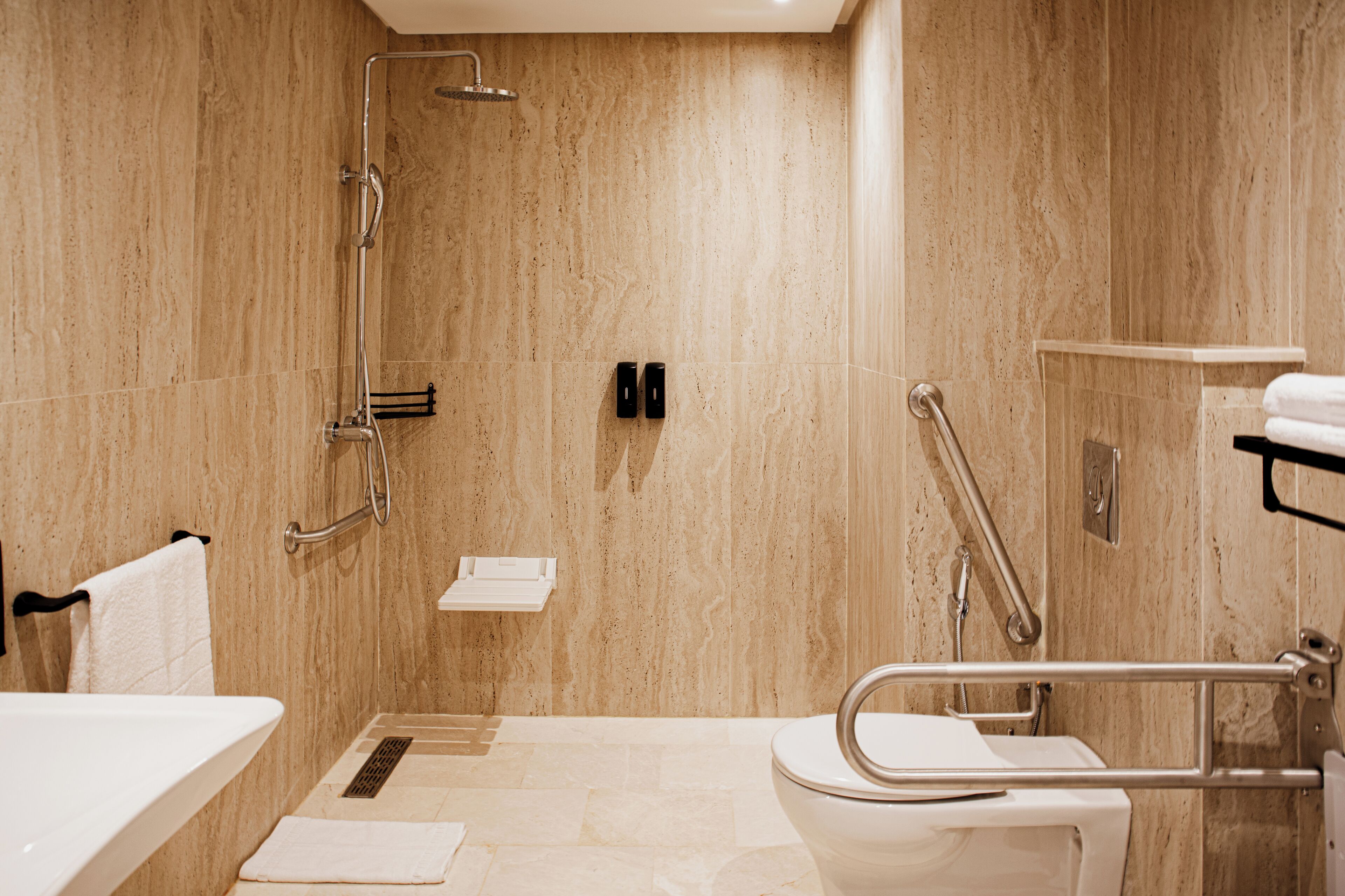 A modern bathroom with a shower, toilet, and sink.