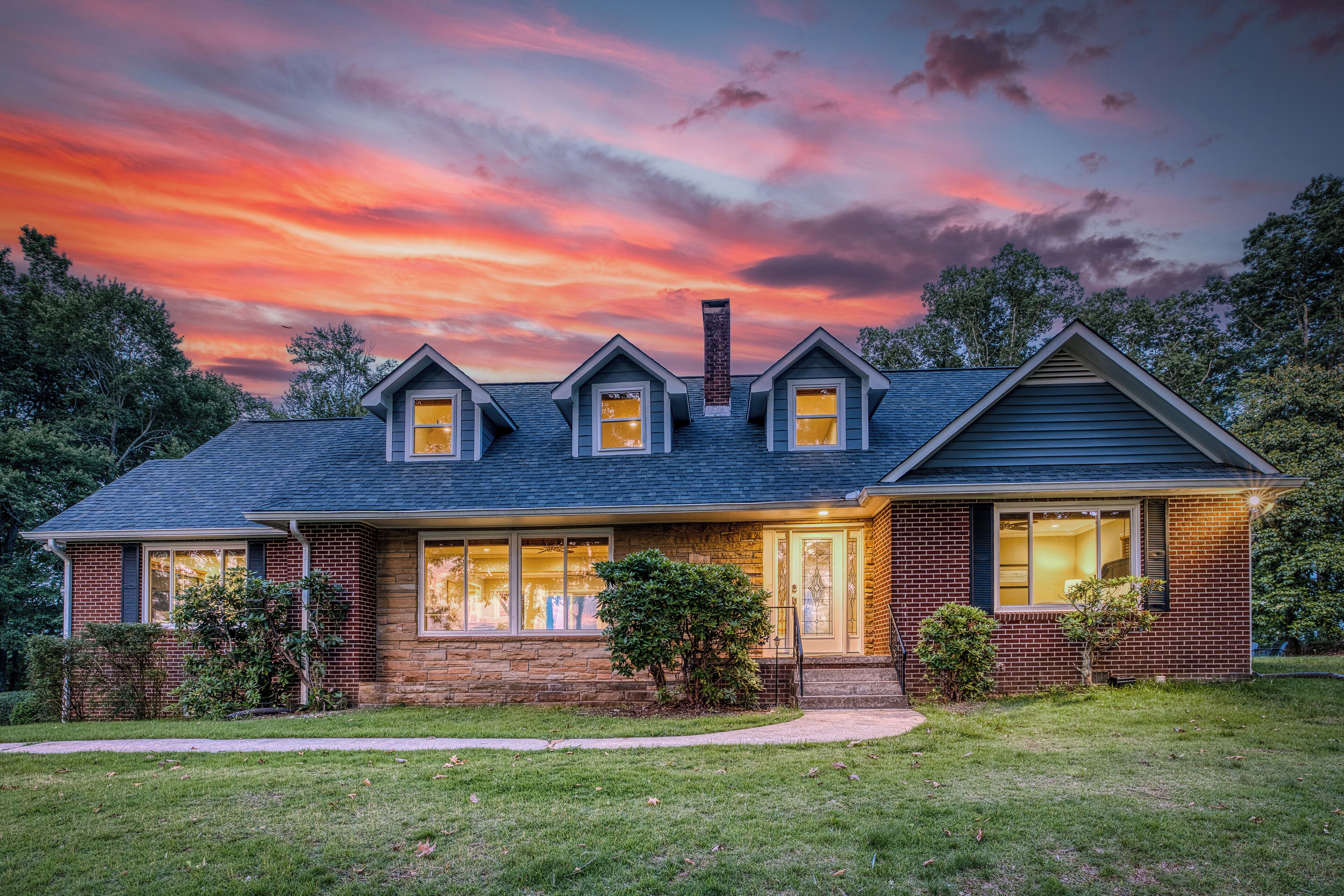 A two-story house with a brick facade, a gabled roof, and a front porch.