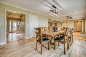 A spacious dining area with a wooden table and chairs, a ceiling fan, and a chandelier. - Escape to Hilltop Estate—a newly renovated 5BR, 3BA mountain retreat (Blue Ridge)