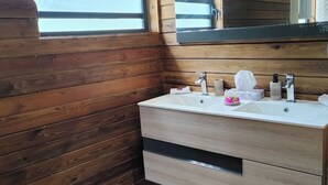 Ein Badezimmer im Holzblockhaus-Stil mit einem weißen Waschbecken und zwei Schubladen.