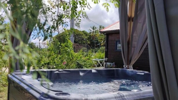 Ein Whirlpool in einem Garten, im Hintergrund ein Haus.