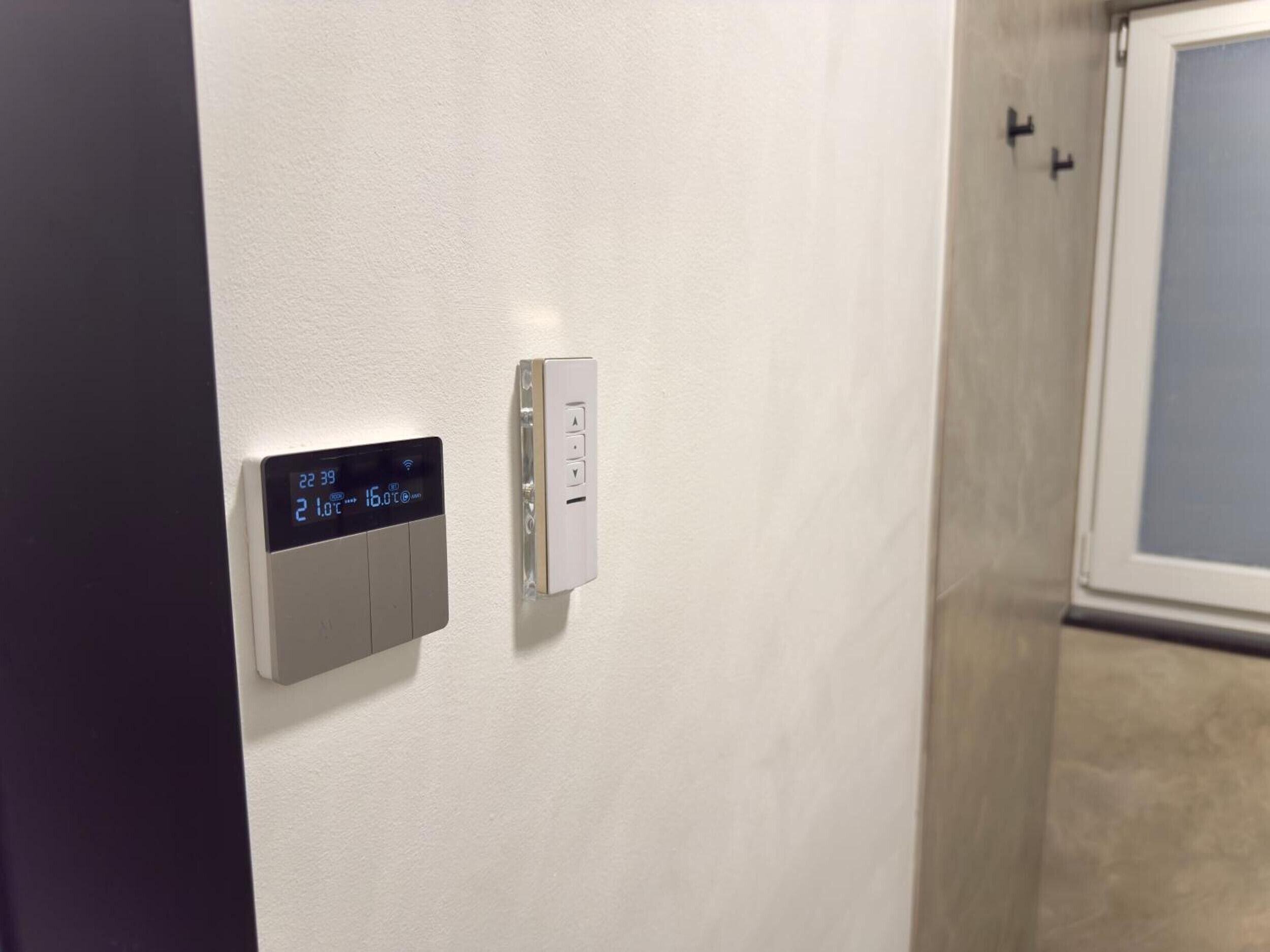 Ein Thermostat und ein Lichtschalter an der Wand.