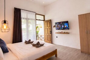 Una camera da letto con un letto, una TV montata a parete e un armadio in legno.