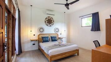 A bedroom with a wooden bed, a ceiling fan, and decorative wall plates.