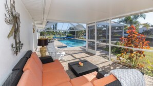 Une terrasse ensoleillée avec une piscine, du mobilier d’extérieur et une vue sur l’espace piscine.