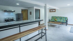Una cocina moderna con encimera de mármol, electrodomésticos de acero inoxidable y un banco de madera.