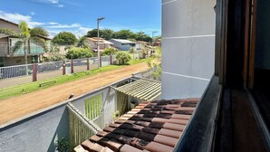 Un balcone residenziale con vista su una strada e case vicine.