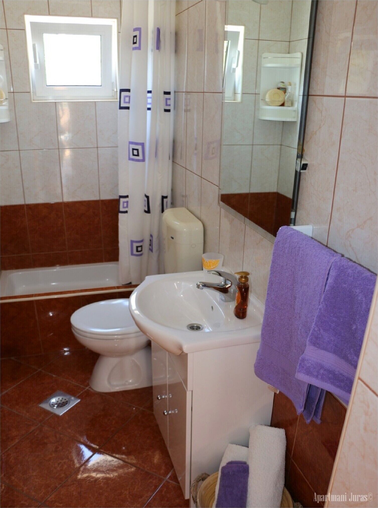 A bathroom with a toilet, sink, and bathtub.