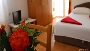 A hotel room with a bed, a television on a small table, and a wooden wardrobe. - Apartments Juras - Studio Apartment with Loggia (Ana) (Rogoznica)