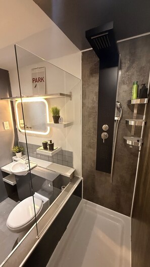 Een douche, handdoeken, zeep, toiletpapier