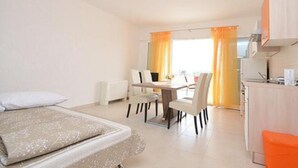 Habitación de hotel con una cama, un escritorio y una silla. Cuenta con una ventana con cortinas.
