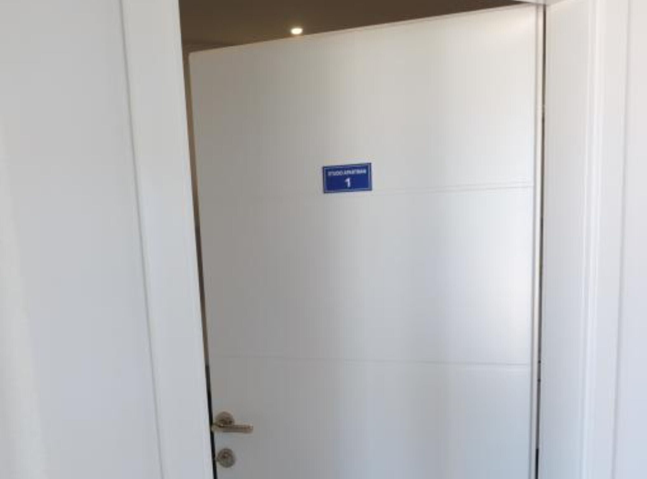 A closed door with a blue sign indicating room number 1.