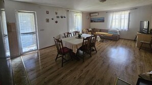 Amplia sala de estar con una mesa de comedor, sillas, sofá y televisor.
