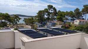 A rooftop with solar panels, a view of the sea, and surrounding buildings. - Apartments Verović Rab Banjol - One Bedroom Apartment With Terrace (A4) (Banjol)