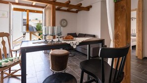 Un'accogliente sala da pranzo con tavolo in legno, sedie e vista sull'esterno.