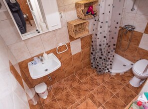 A bathroom with a sink, toilet, and shower area. There are wicker baskets on the wall and a shower curtain with a geometric pattern. - Exquisite Holiday Home with Private Pool and Sauna - Three Bedroom Holiday Home (Tribalj)