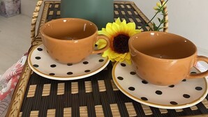A tray with two ceramic cups and saucers, a green kettle, and a sunflower. - Pousada Cantinho da Jake (Penha)