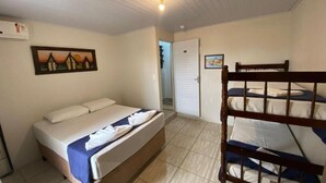 A bedroom with a single bed, a bunk bed, a door, and a wall-mounted air conditioning unit. - Pousada Cantinho da Jake (Penha)