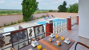 A balcony with a pool, outdoor seating, and breakfast items. - Awesome home in Polaca (Polaca)