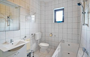 Une salle de bain avec une baignoire, des toilettes et un lavabo.