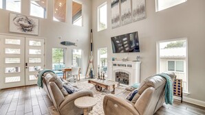 A spacious living room with a fireplace, leather sofas, a television, and a herringbone wood floor. - Private Dock & Yard! Modern Getaway in Mabank (Mabank)