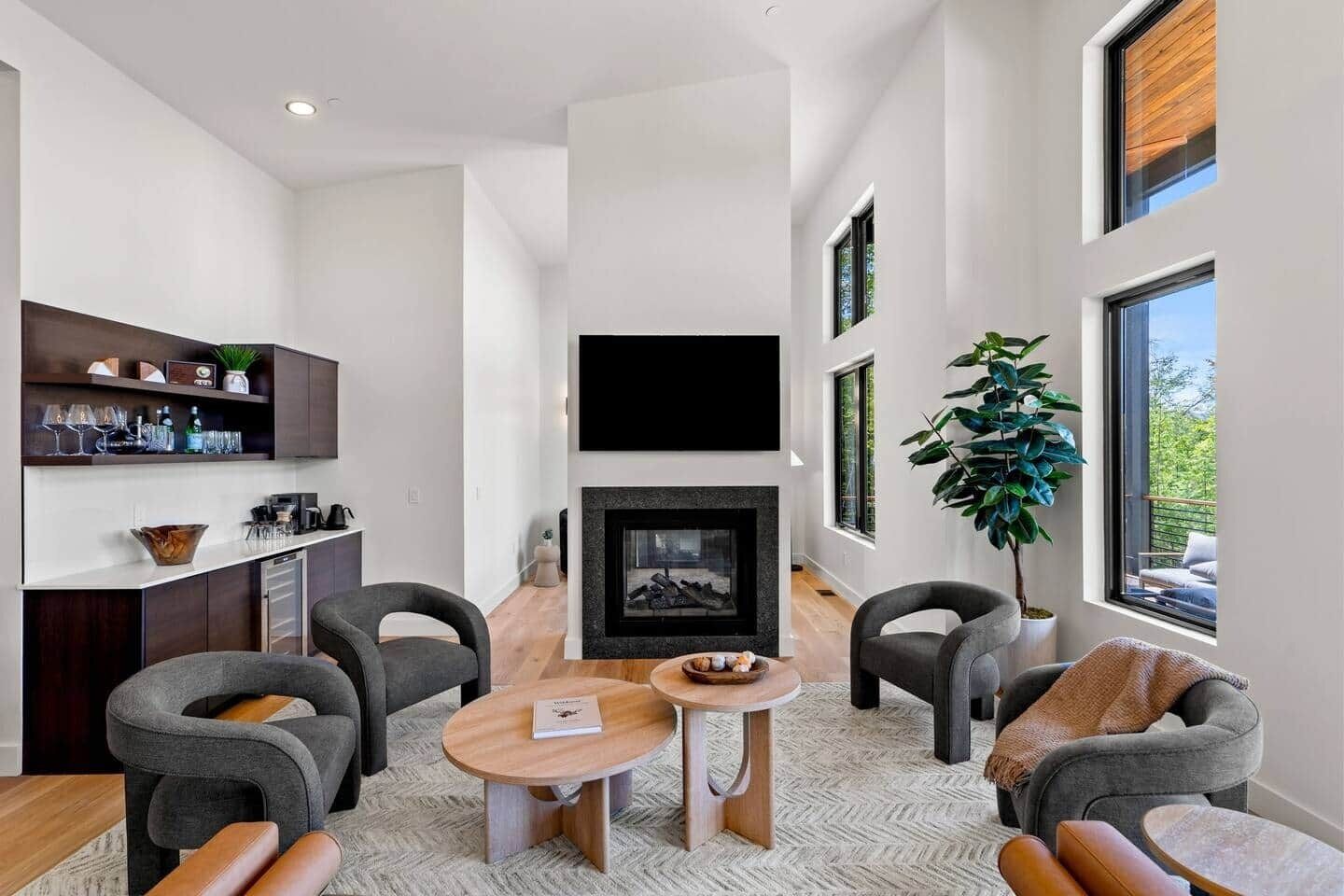 Ein modernes Wohnzimmer mit Kamin, Sitzecke und einer Bar mit Regalen.