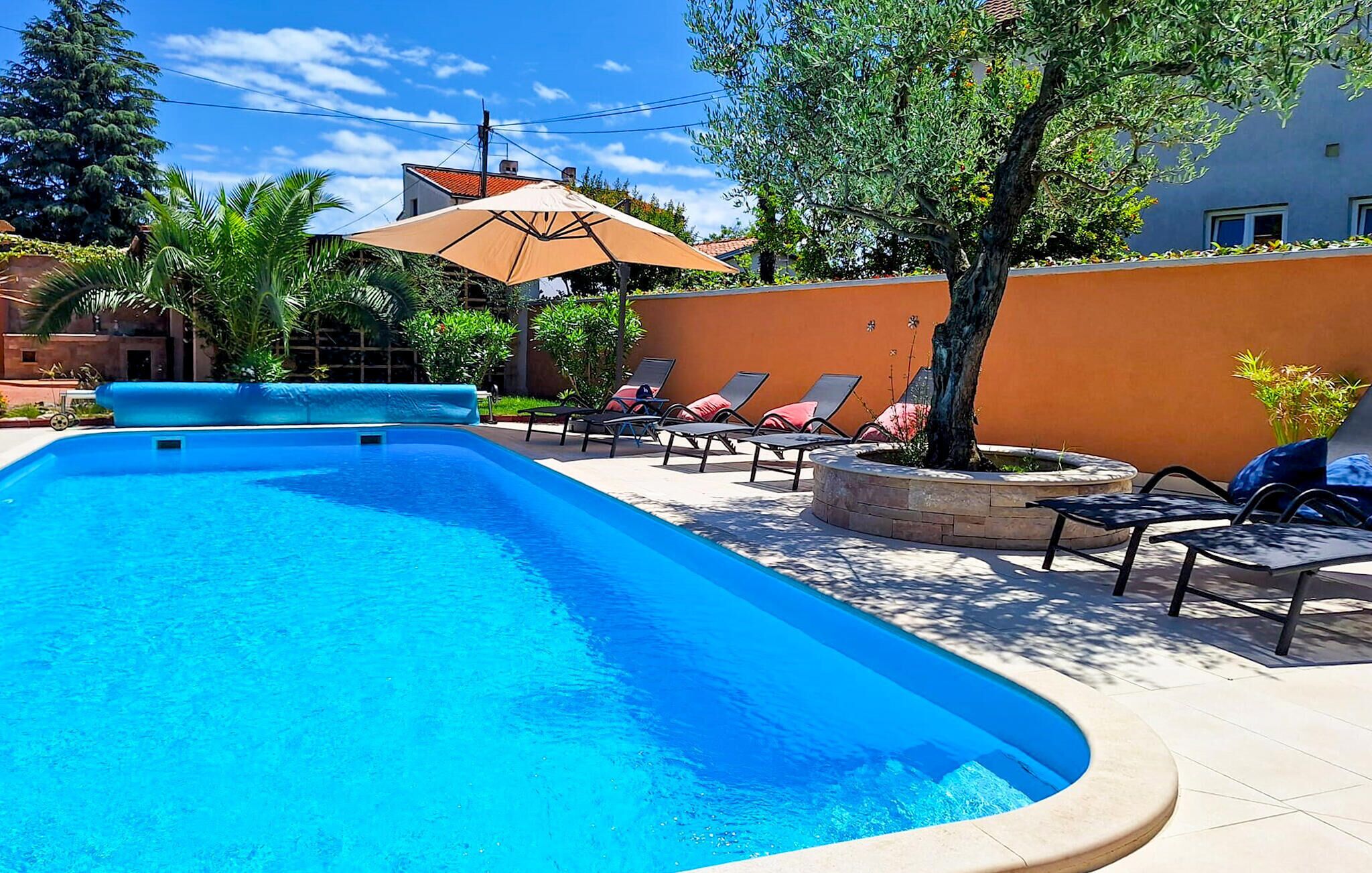 A swimming pool with lounge chairs and a pergola.