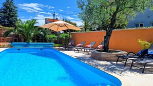 Une piscine avec des chaises longues et une pergola.