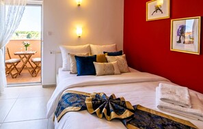 A hotel room with a bed, pillows, a blanket, a table with chairs, and a view through a window. - Gorgeous apartment in Medulin (Medulin)
