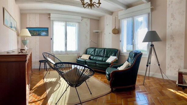 A living room with a green leather sofa, two black wireframe chairs, a wooden cabinet, and a floor lamp. - Family home near the beach, enclosed garden, 4 bedrooms, sleeps 10 (Loctudy)