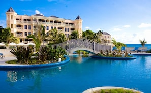 Ein Resort mit großem Pool, einer Brücke und einem Gebäude mit mehreren Balkonen.