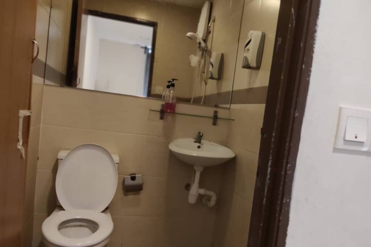 A small bathroom with a toilet, sink, and a mirror.