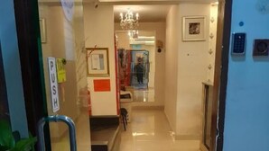 A hotel lobby with a tiled floor, a chandelier, a reception desk, and a 'PUSH' sign on the door. - NOVA HOTEL BUKIT BINTANG (Kuala Lumpur)