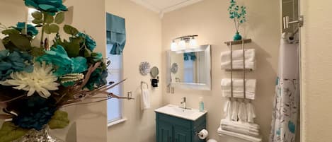 A bathroom with a vanity, a mirror, a towel rack, and a toilet.