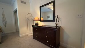 A hallway with a dark wooden dresser, a floor lamp, and a mirror on the wall. - Lakeview HOUSE W/Hot Tub | 2 Units | 3 Bedrooms (Rocky Mount)