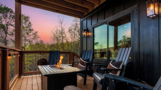 Un terrazza in legno con posti a sedere all'aperto e un elemento decorativo a fuoco.