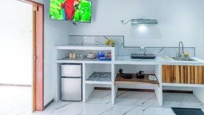 A compact kitchen with a built-in refrigerator, a microwave, a sink, and a wooden countertop. - Studio Apartment #7 w/ Smart TV, A/C + Pool (Playa negra)