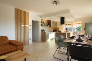 Une cuisine moderne avec un coin repas, un canapé et un téléviseur.