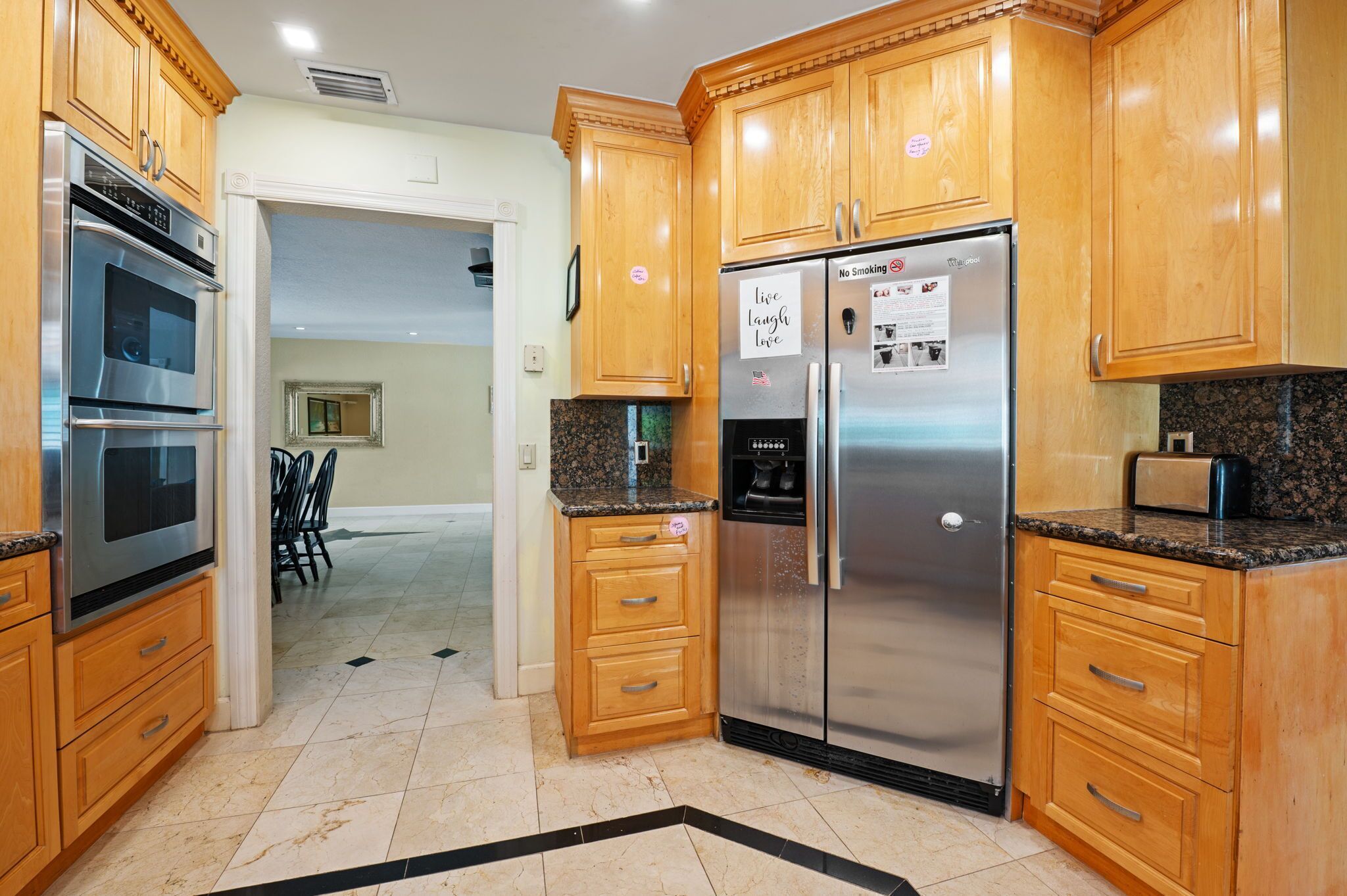 A kitchen with wooden cabinets, stainless steel appliances, and a granite countertop.