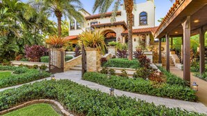 A Mediterranean-style villa with a courtyard, stone steps, and lush landscaping. - Mediterranean Waterfront Estate on Caloosahatchee (Fort Myers)