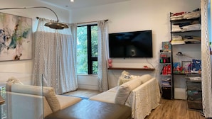 Una sala de estar moderna con un sofá, un televisor y una estantería.