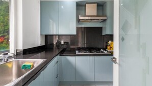 A modern kitchen with light blue cabinets, a stainless steel sink, and a gas stove.