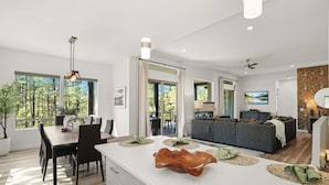 A modern interior with a dining area, kitchen, and living space, featuring large windows and a view of the outdoors. - Luxury Lodge | Hot Tub + Views | 5 Min to DT (Prescott)