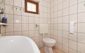 Une salle de bain avec des toilettes, un lavabo et une baignoire.