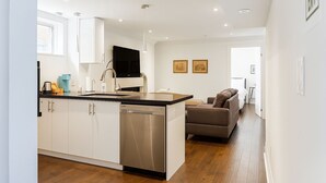 A modern kitchen with a central island, stainless steel appliances, and a flat-screen TV. - Comfortable Mississauga Stay, Private Entry, Laundry & Wi-Fi (Mississauga)